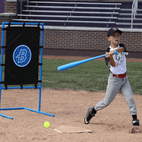 Young boy swinging a bat at a baseball near the Blitzball StrikeZone Target during practice