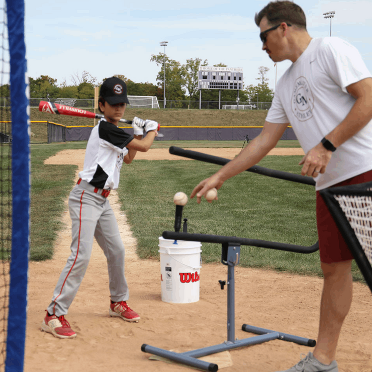 Baseball swing trainer bundle for youth training with an instructor guiding a young player