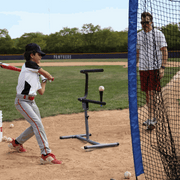Young player using the baseball swing trainer bundle at a baseball field with a coach observing