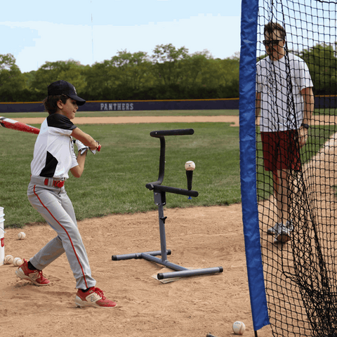 Young player using the baseball swing trainer bundle at a baseball field with a coach observing