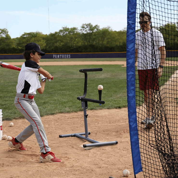 Young player using the baseball swing trainer bundle at a baseball field with a coach observing