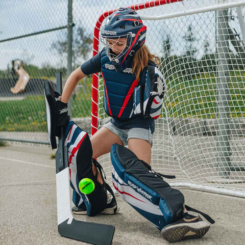 Young player in goalie gear preparing to play with Road Warrior Street Hockey Balls - 15 Pack (Extreme Colours)
