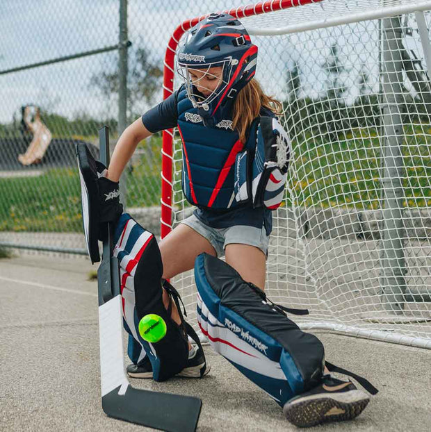 Young player in goalie gear preparing to play with Road Warrior Street Hockey Balls - 15 Pack (Extreme Colours)
