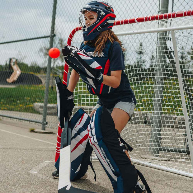 Road Warrior Street Hockey Balls - 15-Pack - Orange in action during a street hockey game with a goalie