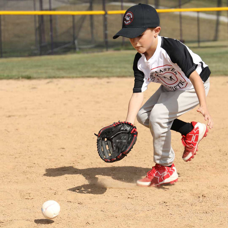 Young player practicing with Slugger Training Swax training baseball on a dusty field