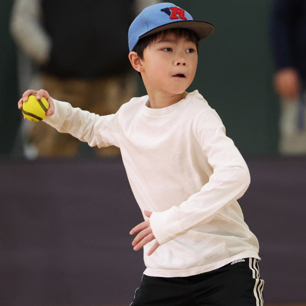 Young boy throwing a USA Baseball Baseball5 Ball during practice in a gymnasium