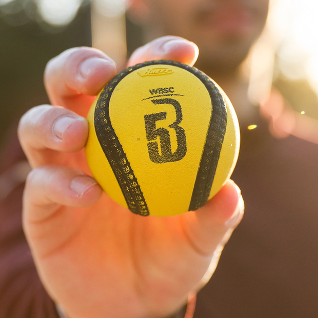Hand holding a yellow USA Baseball Baseball5 Ball designed for optimal performance in games