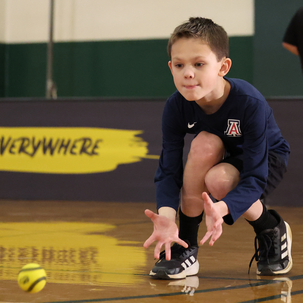 Young boy playing with a USA Baseball Baseball5 Ball, demonstrating athletic skills indoors
