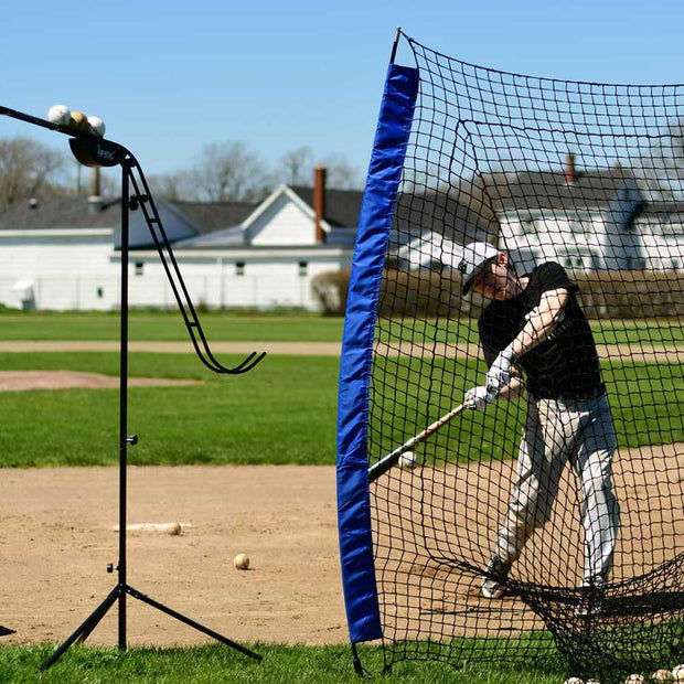 Player practicing hitting with Louisville Slugger portable practice sock net on a sunny baseball field