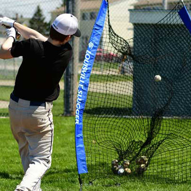 Youth player swinging bat at baseball into Louisville Slugger portable practice sock net for training