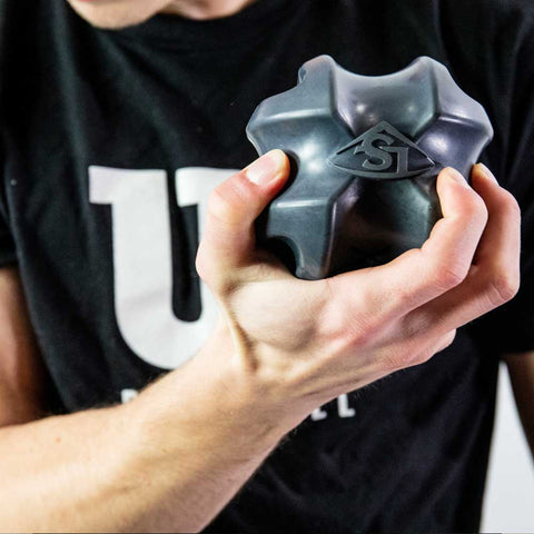 Male athlete holding the Louisville Slugger XBALL grip strength & recovery trainer for hand exercises