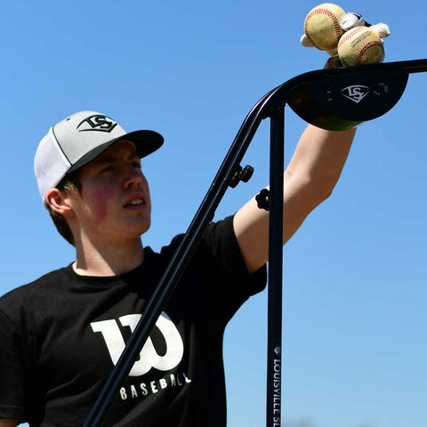 Louisville Slugger soft-toss system for batting practice with adjustable arm and baseballs ready for use