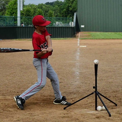 Youth using a Louisville Slugger soft-toss system for batting practice at a baseball field